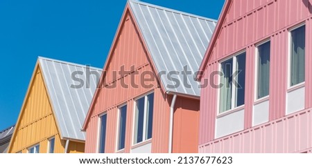 Panorama lookup view of metal roof on row of new development colorful house with clear blue sky background.  Close-up facade of two story townhomes near Wheeler District, Oklahoma City, USA