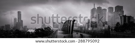 panorama of melbourne of a cold winter morning loking over a walk bridge towards the city centre with lots of clouds