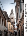 Panorama of the Mestni Stolp city tower of Koper, seen from a typical narrow medieval street, with the praetorian palace. koper is a slovenian town of istria.