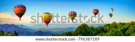 Panorama of mountain with hot air balloons on morning at Thailand.