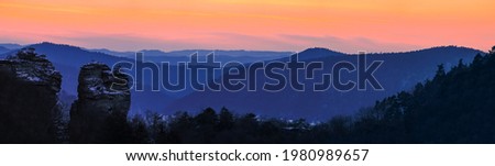panorama of mountain layers during blue hour with beutiful orange sky, twilight, sky after sunset