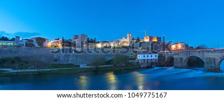 Panorama at night landscape of the city of Barcelos, district Braga, Portugal. Landscape on the river Cavado, Barcelos bridge, Paco dos Condes, water mill and church. Buildings all in stone