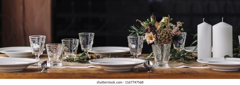 Panorama Of Noble Lifestyle Table Decoration Set For Thanksgiving, Precious Glasses, Floral Decor, White Candles, Autumnal Flowers, White Porcelain On A Long Wooden Table. Still Life Dinner, Wood