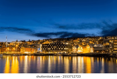 Panorama of the Norwegian city of Tromso on a winter evening during the Christmas season. The boat dock and downtown are illuminated by city lights. - Powered by Shutterstock