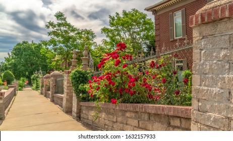 Panorama Pathway along stone and wire fence of ressidential building with red brick wall