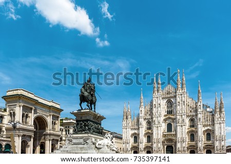 Panorama of the Piazza del Duomo, Milan, Italy. Galleria, monument to Victor Emmanuel II and Milan Cathedral (Duomo di Milano) - famous landmarks of Milan. Sunny view of Milan city on sky background.
