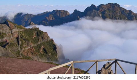 Panorama from Pico do Areeiro, a starting point of PR1 trail to Pico Ruivo. Fog ascending from a valley and remaining among mountain folds. Mountains slopes with mist. Tourists on a hiking trail. - Shutterstock ID 2167635293