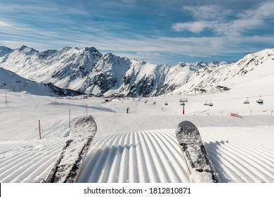 Panorama point of view skier legs on downhill start straight line rows freshly prepared groomed ski slope piste on bright day blue sky background. Snowcapped mountain landscape europe winter resort - Powered by Shutterstock