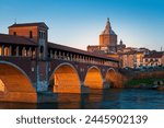 Panorama of Ponte Coperto (covered bridge) and Duomo di Pavia (Pavia Cathedral) in Pavia at sunset, Lombardy, italy.