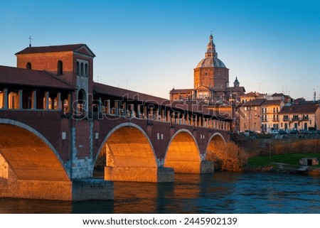 Panorama of Ponte Coperto (covered bridge) and Duomo di Pavia (Pavia Cathedral) in Pavia at sunset, Lombardy, italy.