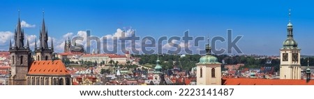 Panorama of Prague city with medieval castle on skyline, old architecture, Cathedrals, gothic towers and spires. Wide landscape of Praga, view on the town with red roofs on houses and top landmarks.