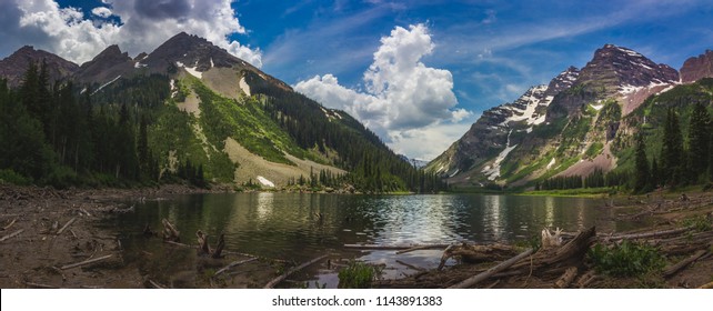 Panorama of Pyramid Peak (left), Maroon Bells (right), and Crater Lake in Snowmass Wilderness in Aspen, Colorado with a blue sky and clouds in summer - Shutterstock ID 1143891383