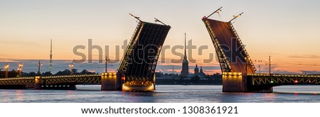 Panorama of raised Palace Bridge (Dvortsovy), Saint Petersburg, Russia. It is landmark of St Petersburg. Panoramic view of Saint Peterburg at White Nights. Landscape of city in evening. Travel theme.