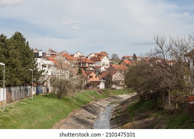 Panorama of Resnik district, with the river topciderska reka passing by a typical suburban settlement with individual residential houses. Resnik is a district of Belgrade in Rakovica municipality. - Shutterstock ID 2101475101