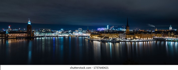 A panorama of the river surrounded by buildings and lights at night in Stockholm in Sweden