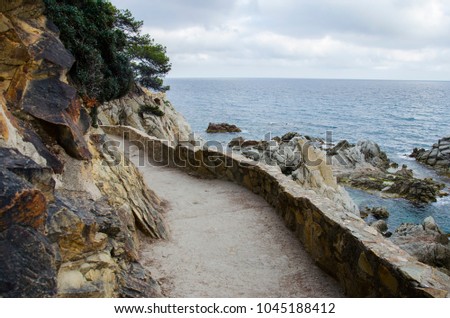 Panorama of Rocks and road near the coast of Lloret de Mar in a beautiful summer day, Costa Brava, Catalonia, Spain. Waterfront of the mountains in Mediterranean sea. Rocks on the coast.