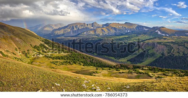 Panorama of\
Rocky Mountain at sunset, with\
rainbow.