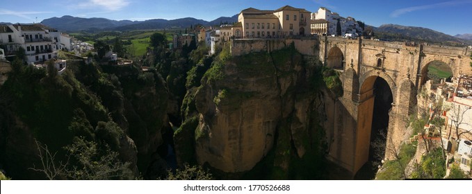 panorama of Ronda medieval stone bridge and gorge in morning light in Andalusia, Spain
