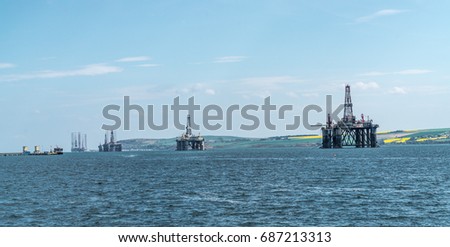 Panorama of a row of decommissioned oil rigs from the North Sea in the Cromarty Firth, Scotland