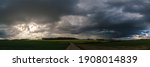 Panorama of rural landscape at wild changing stormy weather condition with rain and sun