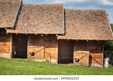 Panorama of Rustic Horse Stables with Wooden Doors and Tiled Roof in the Serbian Countryside, ready to accommodate stallions and horses. - Powered by Shutterstock