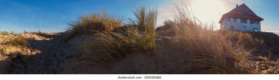 panorama of a sand dune with a beachhouse at Koksijde  in Flanders in a warm autumnal light