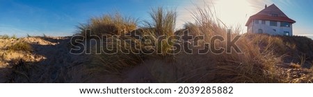 panorama of a sand dune with a beachhouse at Koksijde  in Flanders in a warm autumnal light