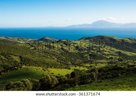 Panorama seen from  a viewpoint between Tarifa and Algeciras in Andalusia, Spain. Green hills, Mediterranean sea, Morocco in Africa in background. Jabel Musa mountain. Landscape. Straits of Gibraltar.