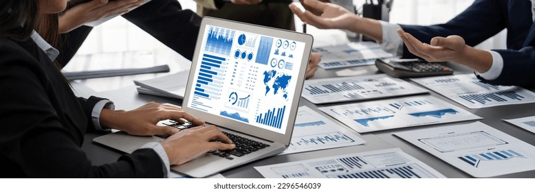Panorama shot analyst team utilizing BI Fintech to analyze financial report with laptop. Businesspeople analyzing BI data dashboard displayed on laptop screen for business insight. Prodigy - Powered by Shutterstock