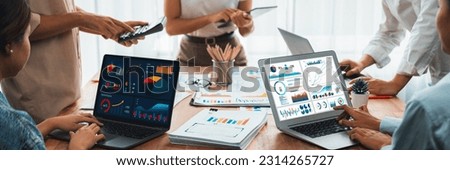 Panorama shot analyst team utilizing BI Fintech to analyze financial report with laptop. Businesspeople analyzing BI power dashboard displayed on laptop screen for business insight. Scrutinize