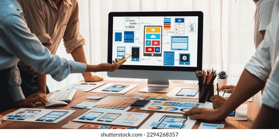 Panorama shot of front-end developer team brainstorming UI and UX designs for mobile app on laptop computer screen. User interface development team planning for user-friendly UI design. Scrutinize - Shutterstock ID 2294268357