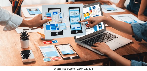 Panorama shot of front-end developer team brainstorming UI and UX designs for mobile app on laptop computer screen. User interface development team planning for user-friendly UI design. Scrutinize - Shutterstock ID 2304027635