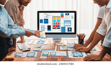 Panorama shot of front-end developer team brainstorming UI and UX designs for mobile app on laptop computer screen. User interface development team planning for user-friendly UI design. Scrutinize - Powered by Shutterstock