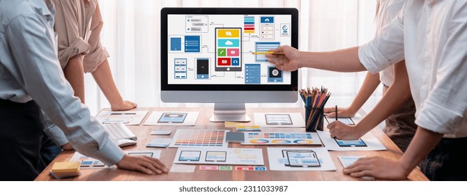 Panorama shot of front-end developer team brainstorming UI and UX designs for mobile app on laptop computer screen. User interface development team planning for user-friendly UI design. Scrutinize - Shutterstock ID 2311033987