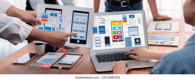 Panorama shot of front-end developer team brainstorming UI and UX designs for mobile app on laptop computer screen. User interface development team planning for user-friendly UI design. Scrutinize - Shutterstock ID 2311048703