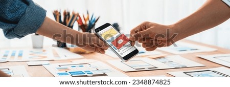 Panorama shot of front-end developer team brainstorming UI and UX designs for mobile app on paper wireframe interface. User interface development team planning for user-friendly UI design. Scrutinize