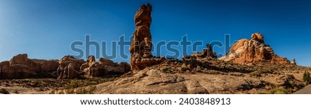 Panorama shot of red sandstone monolith staying infront of other sculptures in arches national park in utah, america, usa