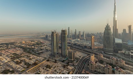 Panorama showing aerial view of tallest towers in Dubai Downtown skyline and highway before sunset. Financial district and business area in smart urban city. Skyscraper and high-rise buildings