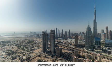 Panorama showing aerial view of tallest towers in Dubai Downtown skyline and highway timelapse. Financial district and business area in smart urban city. Skyscraper and high-rise buildings