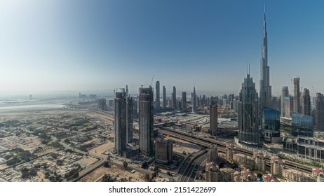 Panorama showing aerial view of tallest towers in Dubai Downtown skyline and highway timelapse. Financial district and business area in smart urban city. Skyscraper and high-rise buildings
