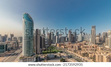 Panorama showing Dubai's business bay and downtown towers aerial morning timelapse. Rooftop view of some skyscrapers and new buildings under construction with thaditional houses of old town district