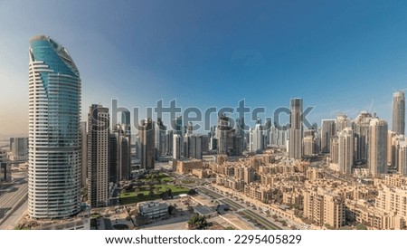 Panorama showing Dubai's business bay and downtown towers aerial morning . Rooftop view of some skyscrapers and new buildings under construction with thaditional houses of old town district