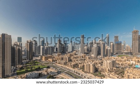 Panorama showing Dubai's business bay and downtown towers aerial morning. Rooftop view of some skyscrapers and new buildings under construction with thaditional houses of old town district