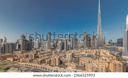 Panorama showing Dubai's business bay and downtown towers aerial morning. Rooftop view of some skyscrapers and new buildings under construction with traditional houses of old town district