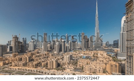 Panorama showing Dubai's business bay and downtown towers aerial morning. Rooftop view of some skyscrapers and new buildings under construction with traditional houses of old town district