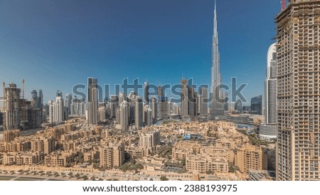 Panorama showing Dubai's business bay and downtown towers aerial morning timelapse. Rooftop view of some skyscrapers and new buildings under construction with traditional houses of old town district