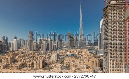 Panorama showing Dubai's business bay and downtown towers aerial morning timelapse. Rooftop view of some skyscrapers and new buildings under construction with traditional houses of old town district