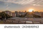 Panorama showing sunset over lawn at Alameda Dom Afonso Henriques with colorful buildings and the Luminous Fountain aerial timelapse. View from above with evening sky in Lisbon, Portugal