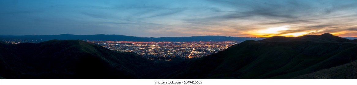 Panorama of Silicon Valley at Night with Lights on and Sunset on the distance