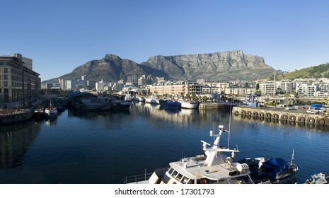 Panorama skyline view of Cape Town, South Africa with the Victoria and Albert harbor and drydocks in the foreground and Table Mountain in the background.